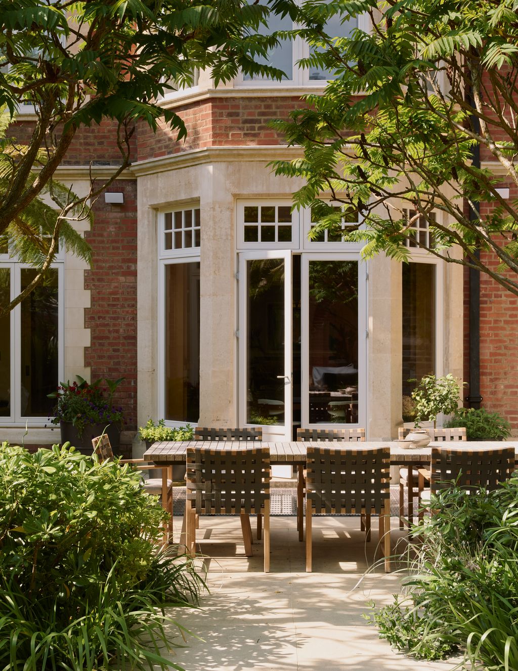 Image may contain Door French Window Window Plant Chair Furniture Desk Table Architecture Building and Housing