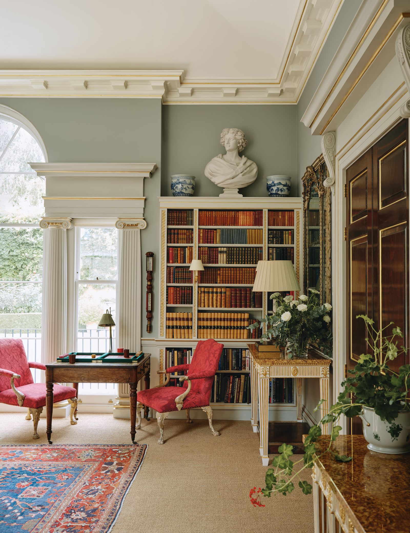 Image may contain Chair Furniture Home Decor Rug Desk Table Person Lamp Plant Architecture Building and Indoors