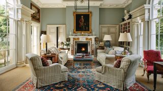 Image may contain Home Decor Architecture Building Furniture Indoors Living Room Room Lamp Fireplace Rug and Chair