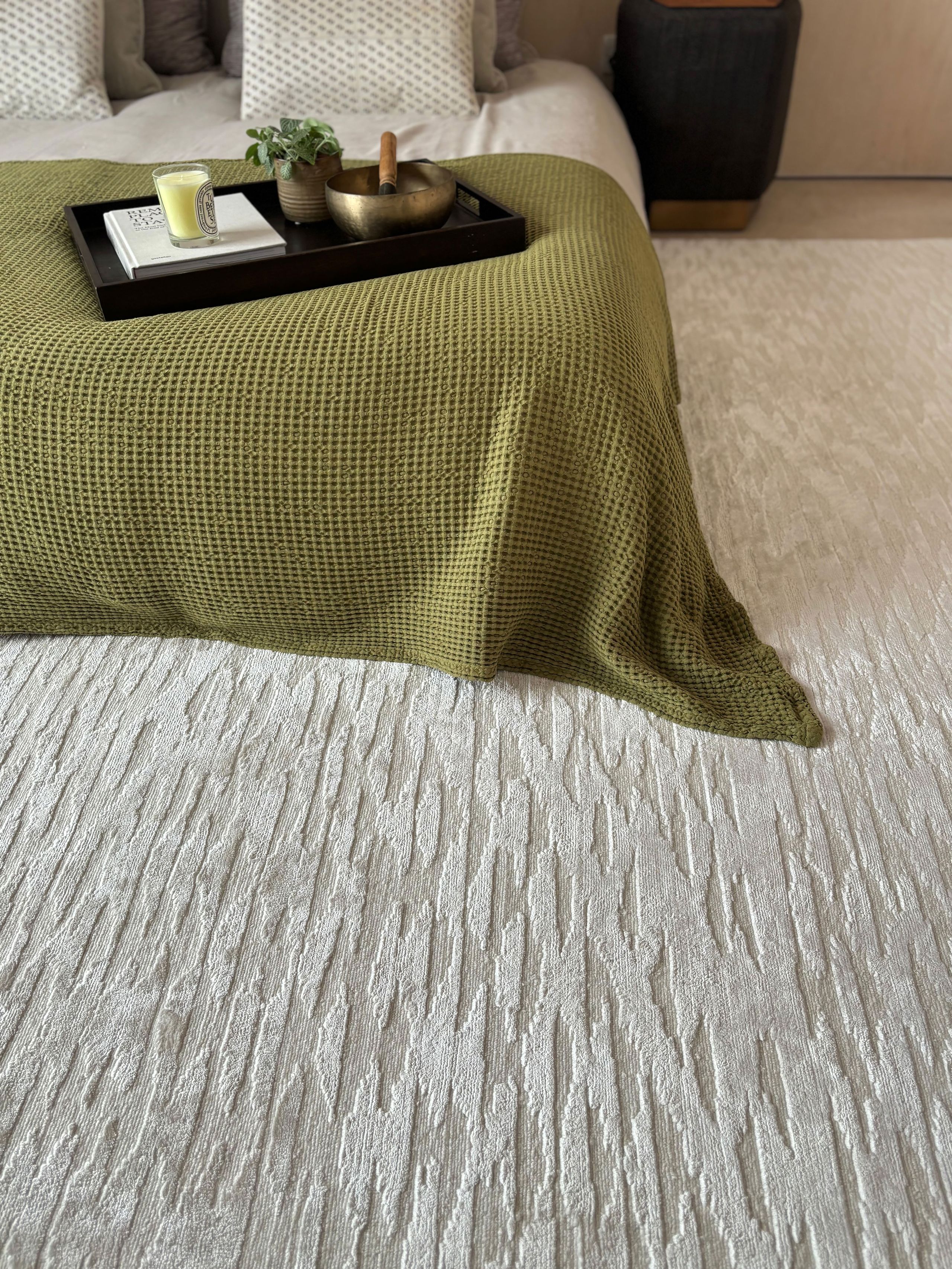 Image may contain: Home Decor, Rug, Plant, Cup, Book, Publication, Floor, and Furniture