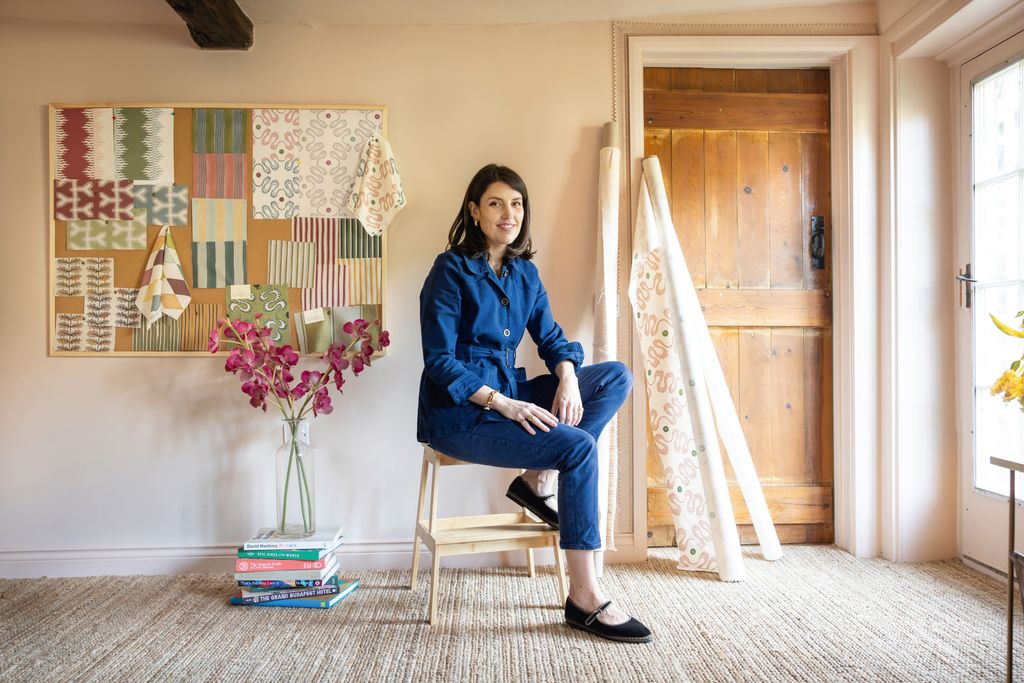 Image may contain Person Sitting Indoors Interior Design Teen Clothing Pants Footwear Shoe Chair and Furniture