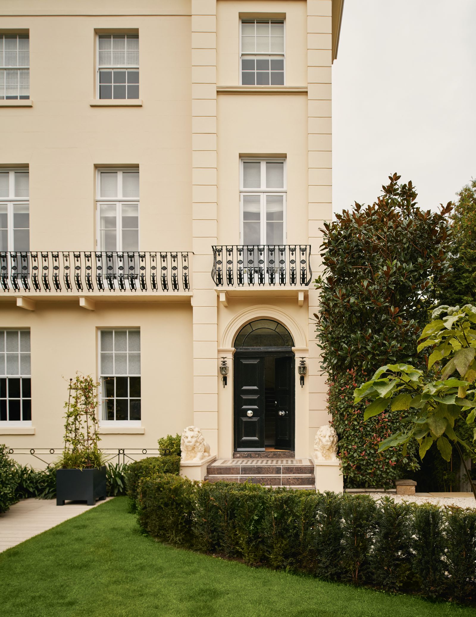 Image may contain Grass Plant City Lamp Architecture Building Housing Fence Hedge Animal Lion and Mammal