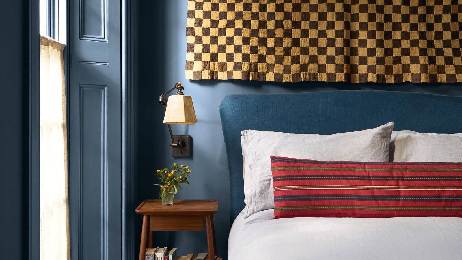 Image may contain: Indoors, Interior Design, Home Decor, Cushion, Bed, Furniture, Wood Panels, Lamp, Pillow, and Bedroom