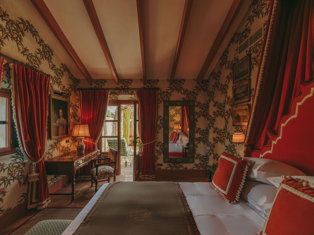 Image may contain Home Decor Lamp Desk Furniture Table Chair Art Painting Person Bed Bedroom Indoors and Room