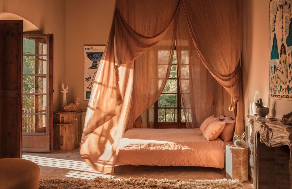 Image may contain Furniture Bed Bedroom Indoors Room Plant Home Decor Rug Desk Table Canopy Bed Art and Painting