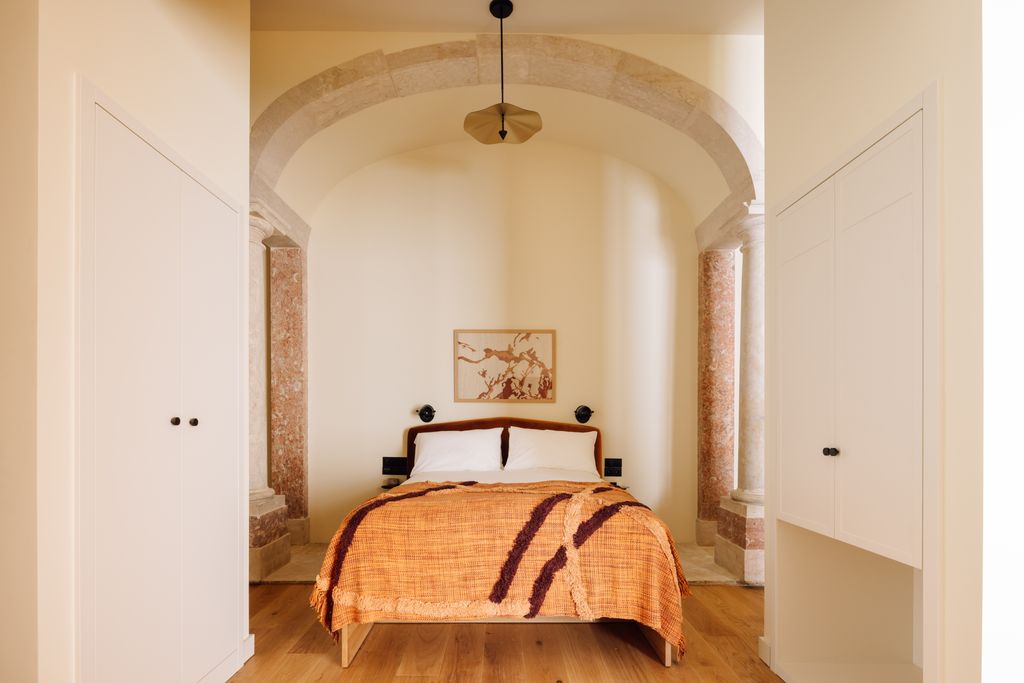 Image may contain Indoors Interior Design Lamp Bed Furniture Corner Architecture Vault Ceiling Arch and Art