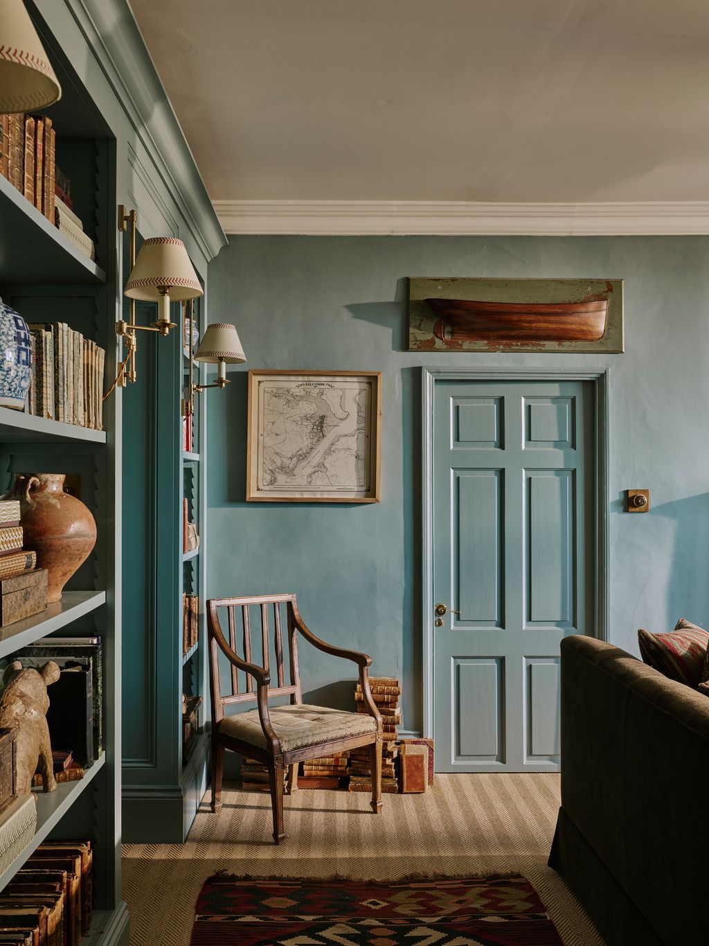 Image may contain Chair Furniture Home Decor Rug Indoors Interior Design Art Painting Couch Lamp and Bookcase