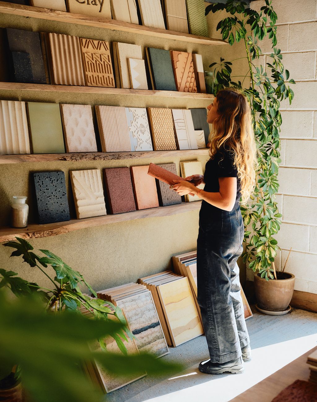 Image may contain Clothing Pants Furniture Plant Adult Person Table Desk Footwear Shoe and Bookcase