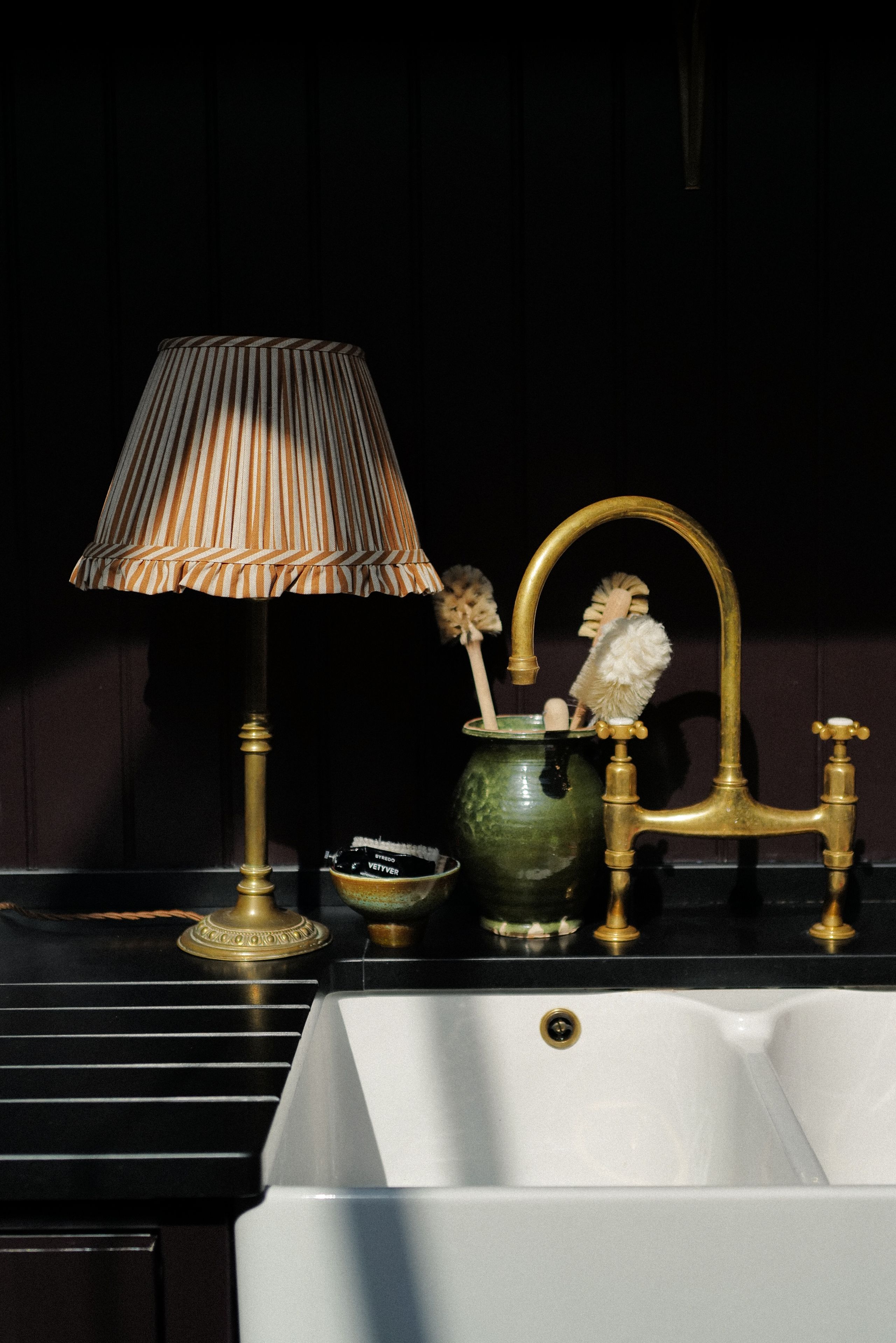 Image may contain: Lamp, Sink, Sink Faucet, Bronze, Indoors, and Interior Design