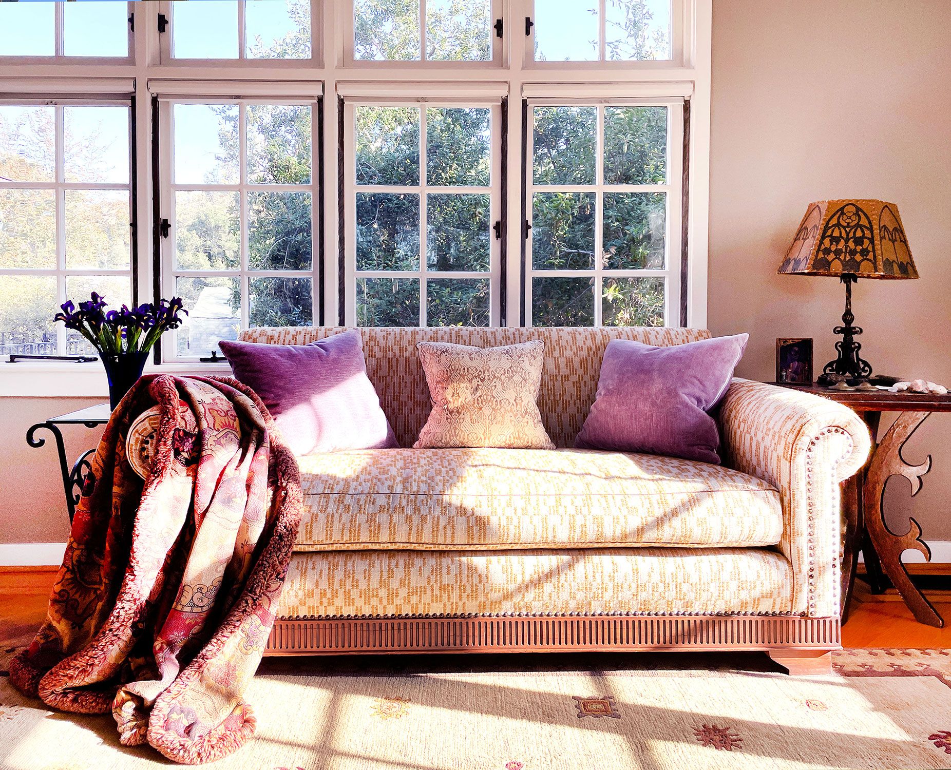 Image may contain: Lamp, Couch, Furniture, Cushion, Home Decor, Desk, Table, Window, Rug, Pillow, Art, and Painting