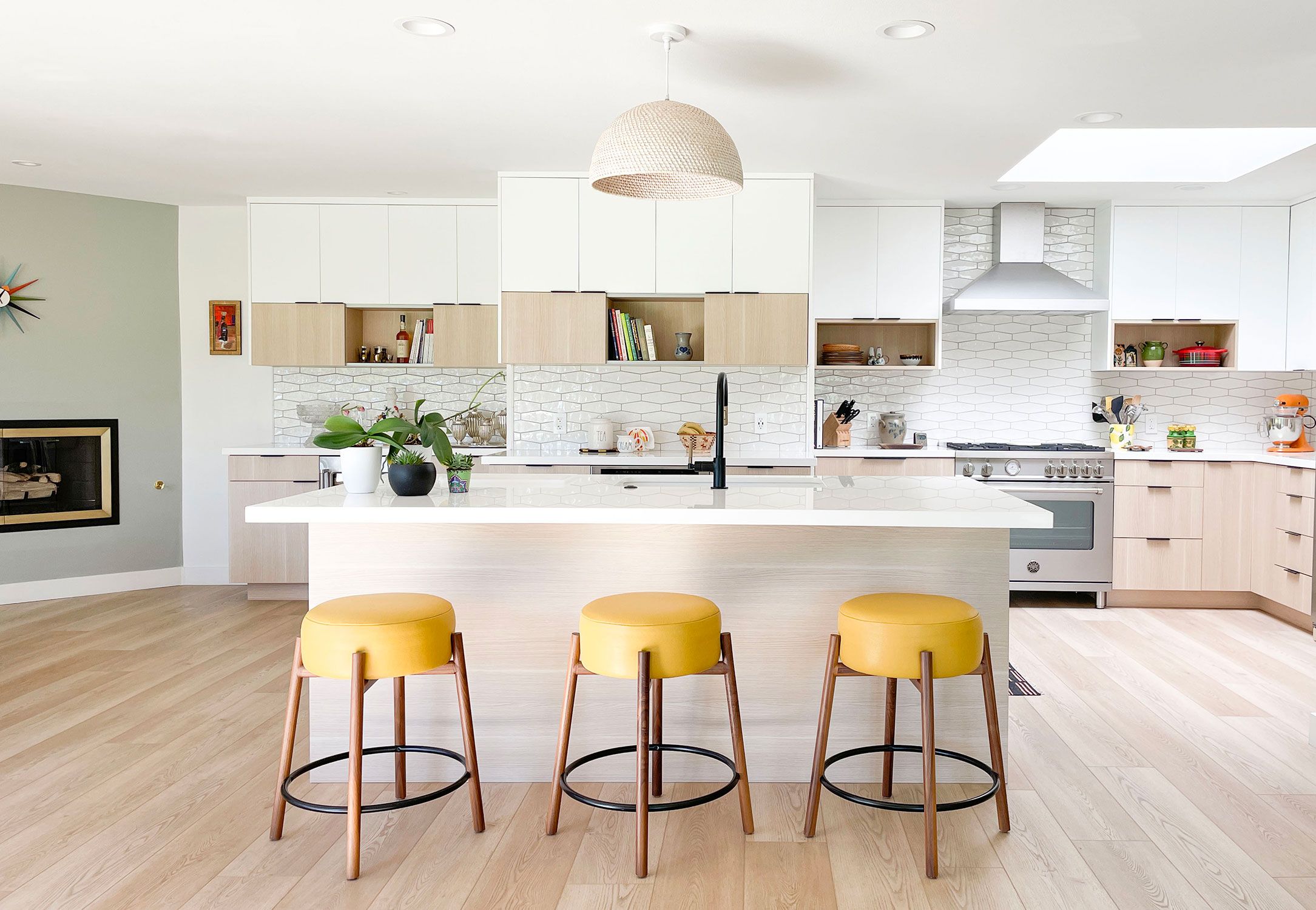 Image may contain: Indoors, Kitchen, Interior Design, Bar Stool, Furniture, Kitchen Island, Art, Painting, Cooktop, and Plant