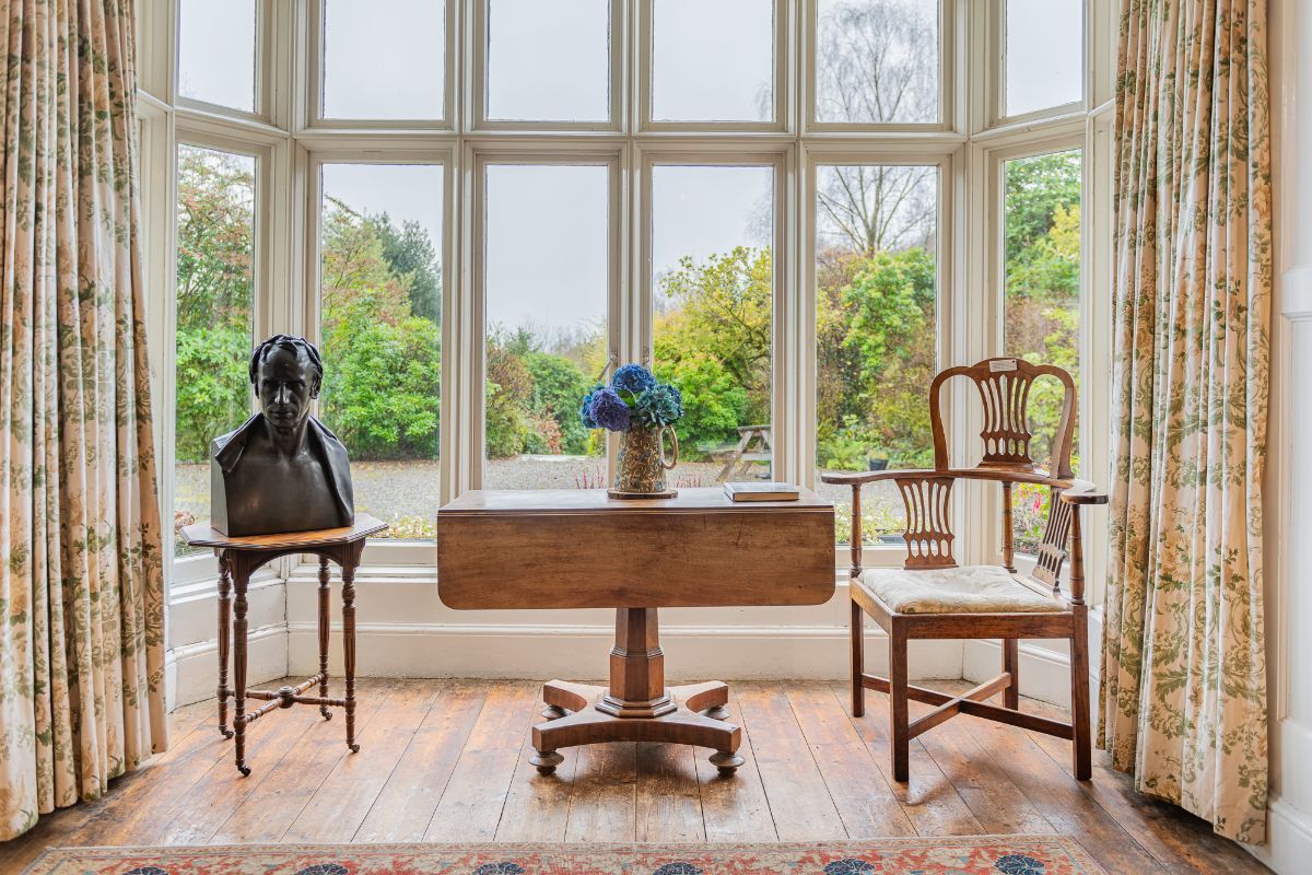 Image may contain Balduin Baas Window Desk Furniture Table Chair Adult Person Bay Window Home Decor and Rug