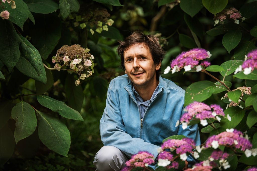 Image may contain Garden Nature Outdoors Leaf Plant Face Head Person Photography Portrait Happy Smile and Adult