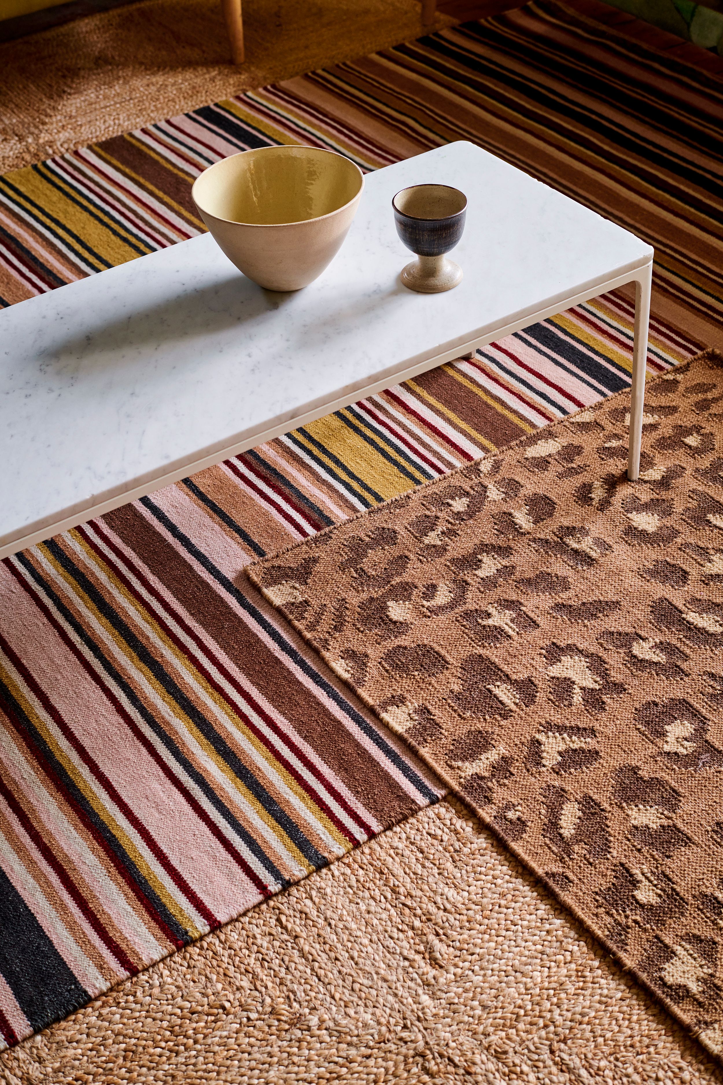 Image may contain: Home Decor, Rug, Cup, Furniture, and Table