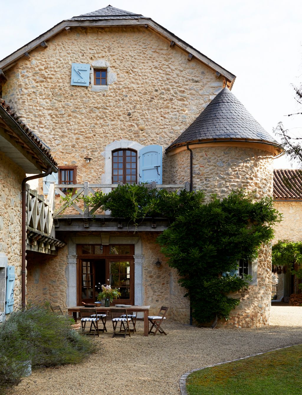 Image may contain Architecture Building Cottage House Housing Villa Chair Furniture Grass Plant Desk and Table