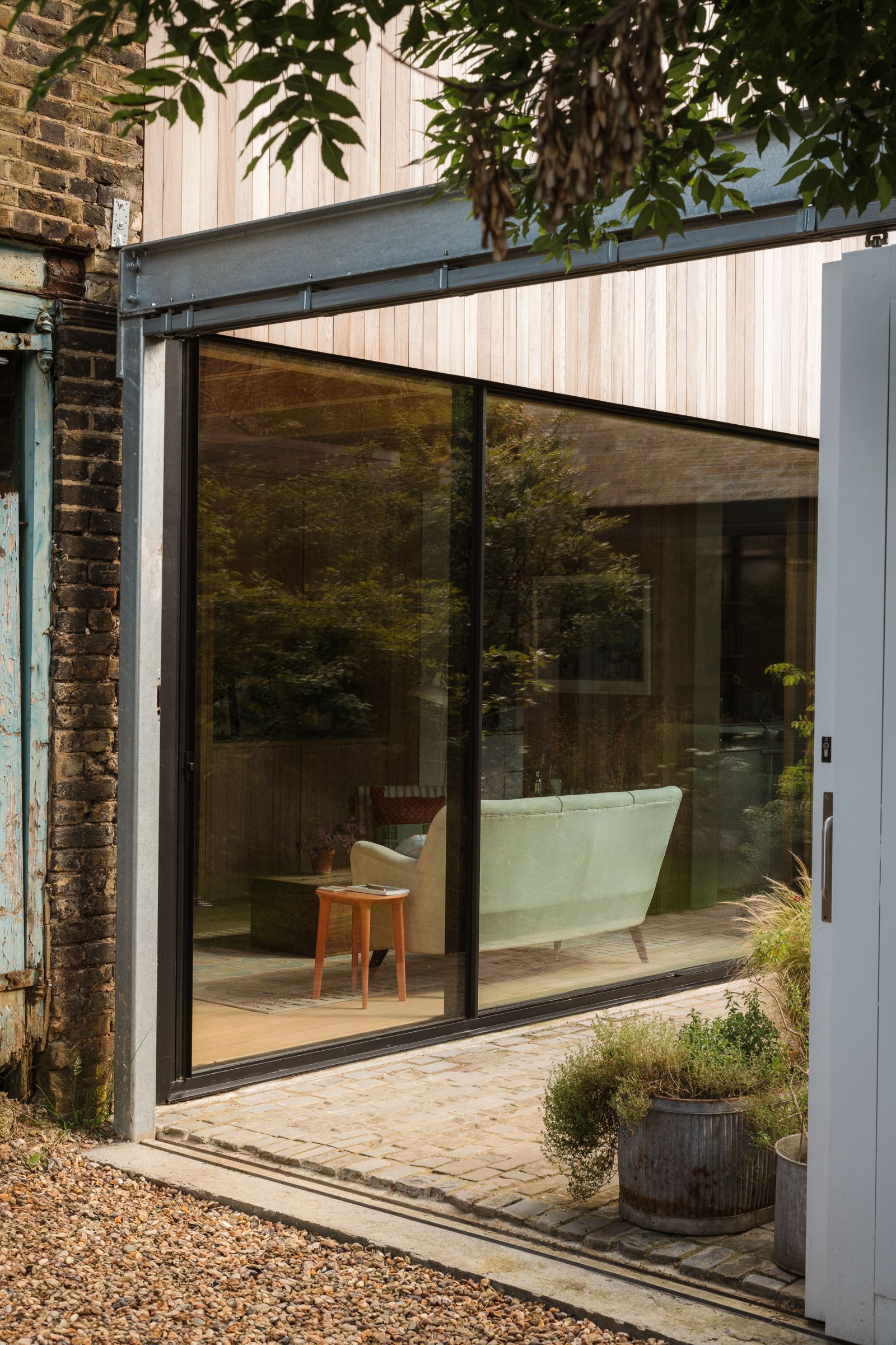 Image may contain Door Plant Couch Furniture Indoors Interior Design Architecture Building Housing House and Desk