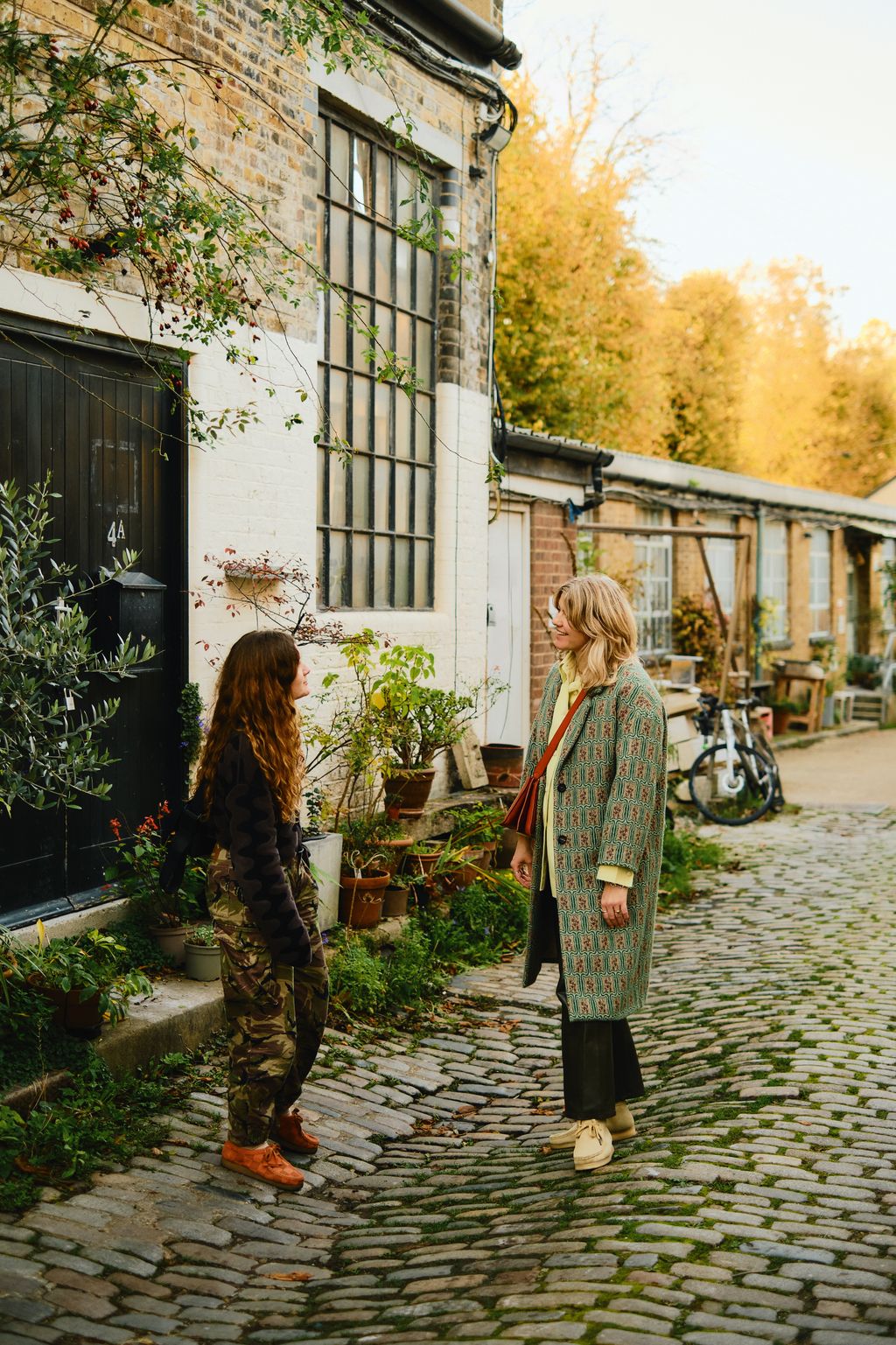 Image may contain Path City Road Street Urban Clothing Footwear Shoe Walkway Adult Person Cobblestone and Plant