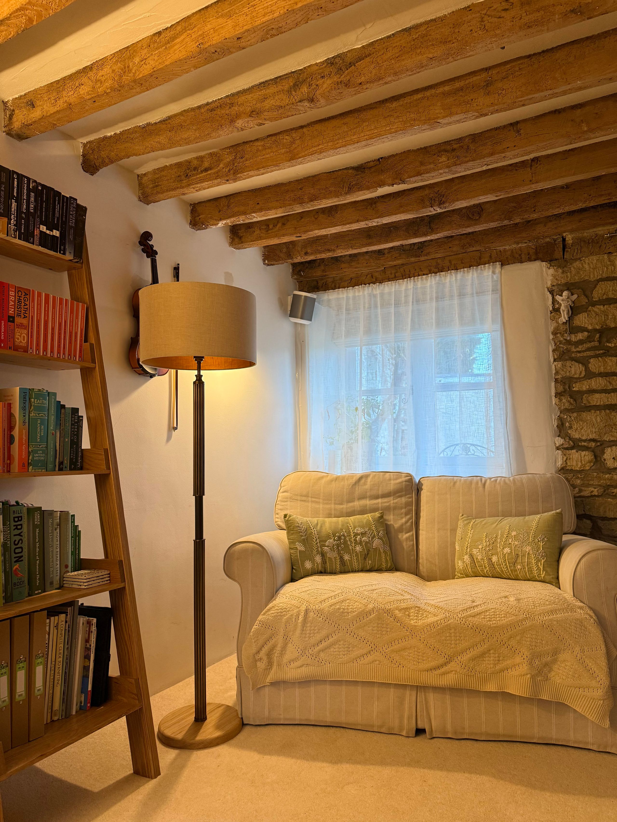 Image may contain: Lamp, Indoors, Interior Design, Couch, Furniture, Person, Floor Lamp, Electronics, and Speaker