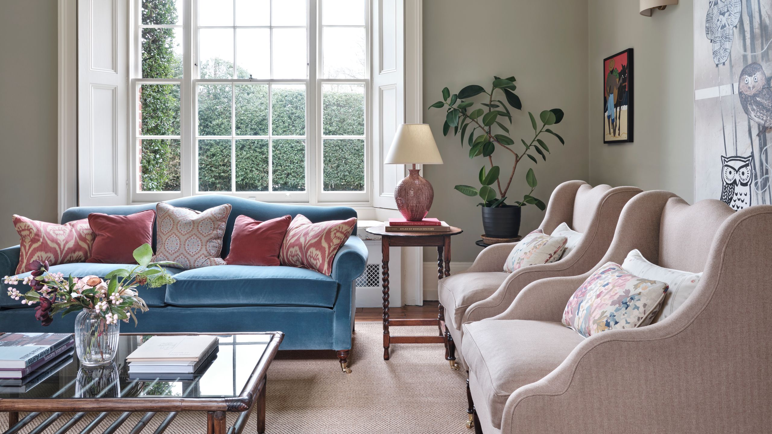 Image may contain: Lamp, Plant, Couch, Furniture, Art, Painting, Desk, Table, Window, Home Decor, Book, and Publication