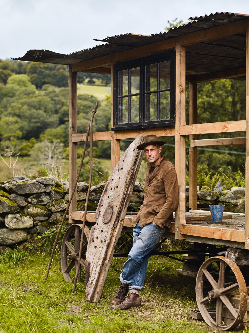 Image may contain Clothing Pants Hat Adult Person Footwear Shoe Cup Sitting Wood Machine Wheel and Outdoors