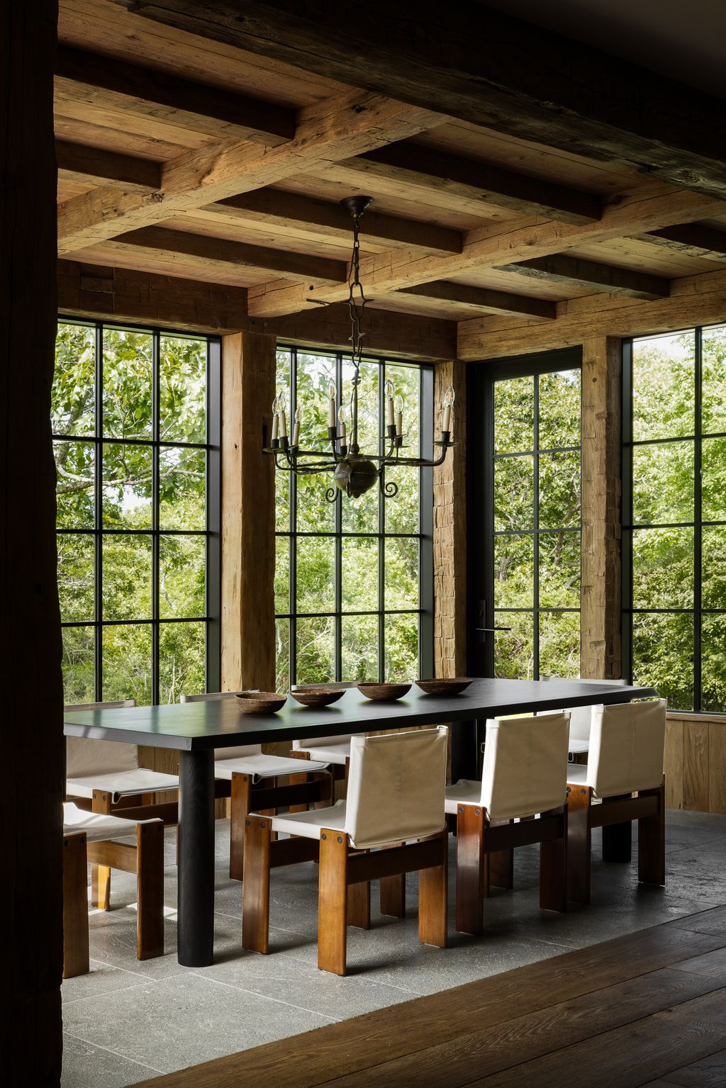 Image may contain Indoors Interior Design Window Desk Furniture Table Chair Lamp Wood Dining Table and Chandelier