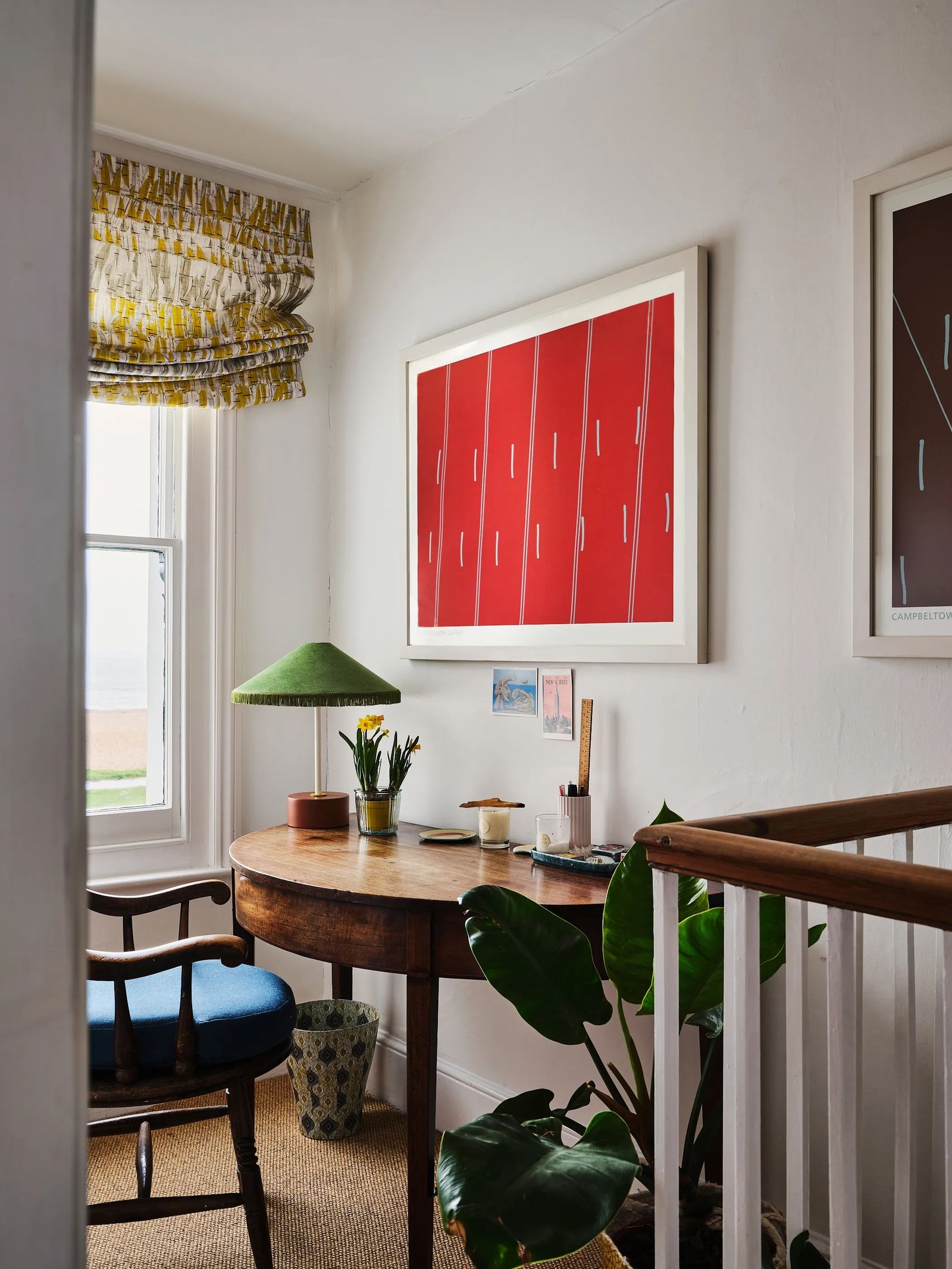 Image may contain Indoors Interior Design Lamp Desk Furniture Table Chair Cup Plant Art Painting and Architecture