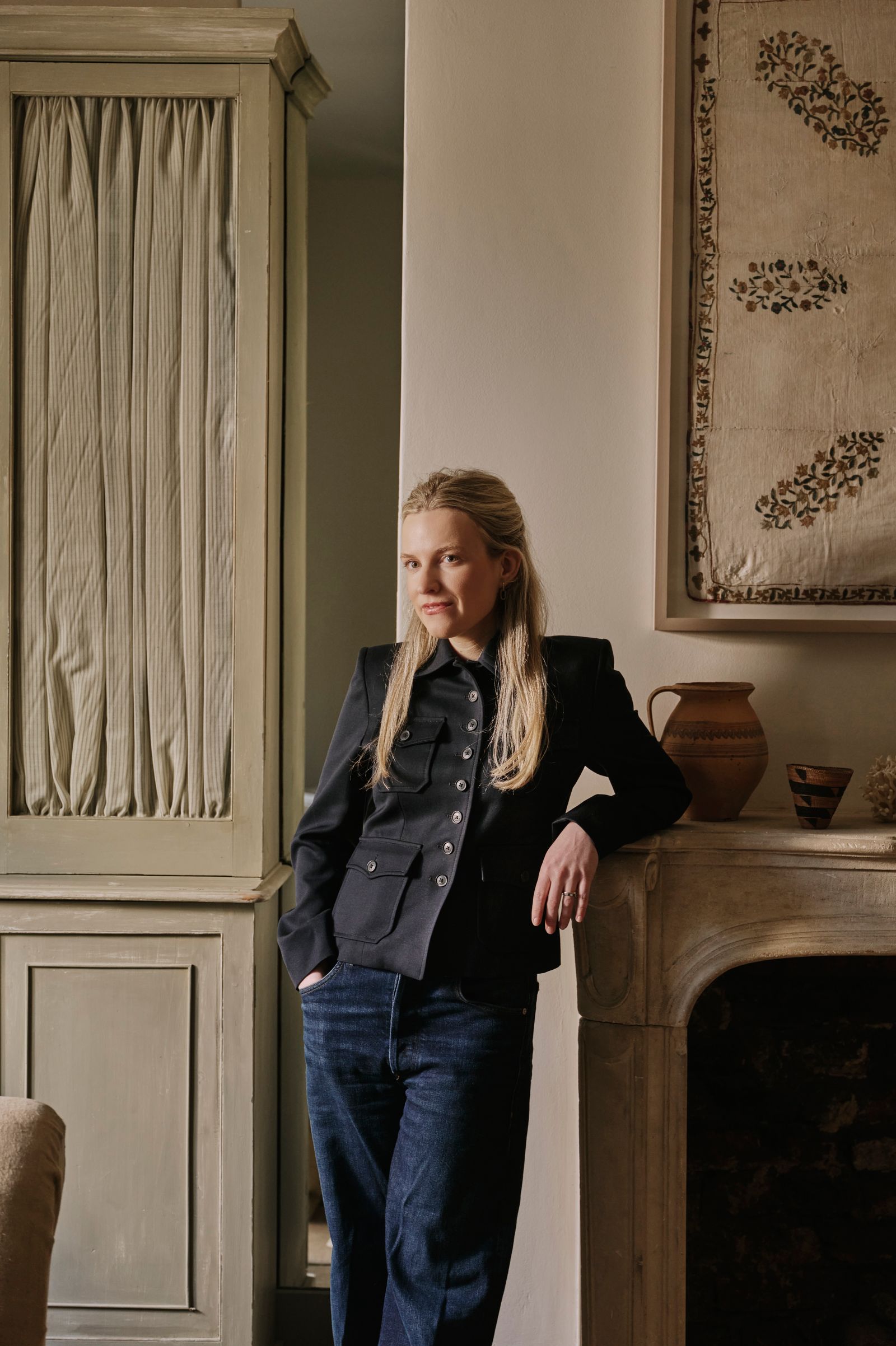 Image may contain Clothing Pants Jeans Blazer Coat Jacket Adult Person Blonde Hair and Formal Wear