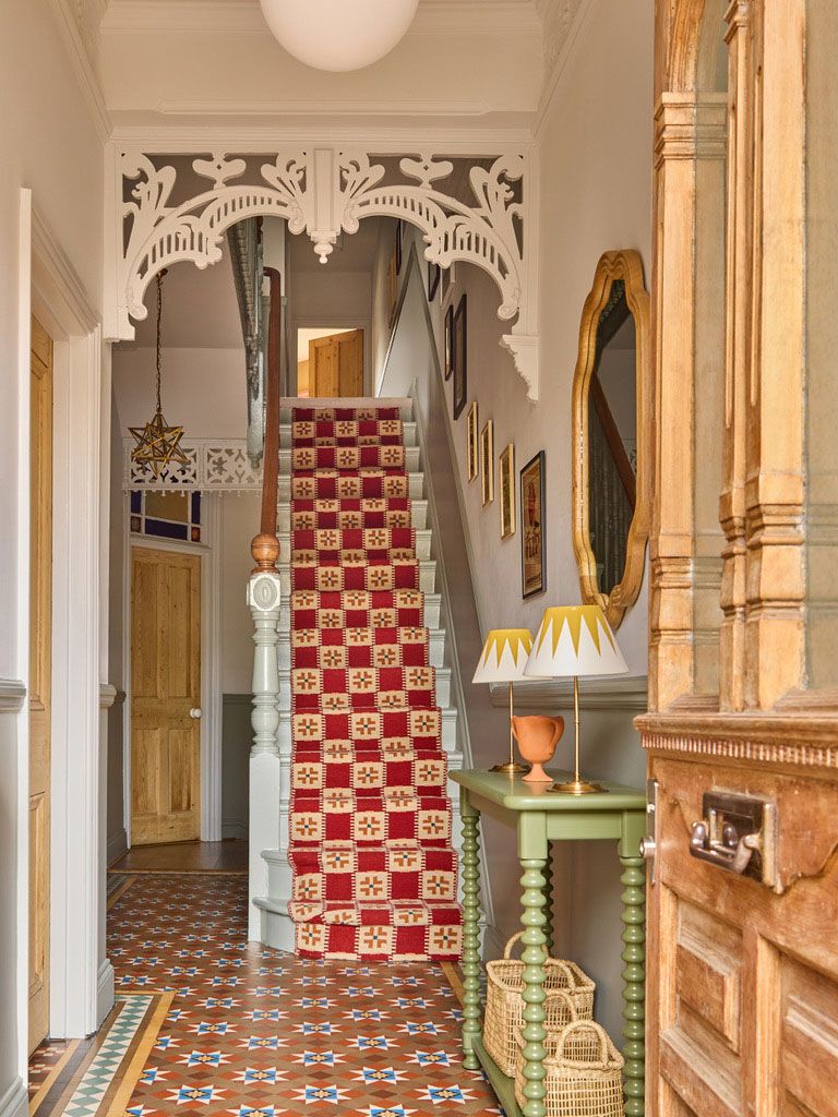 Image may contain: Lamp, Indoors, Architecture, Building, Foyer, House, Housing, Staircase, Art, Painting, and Desk