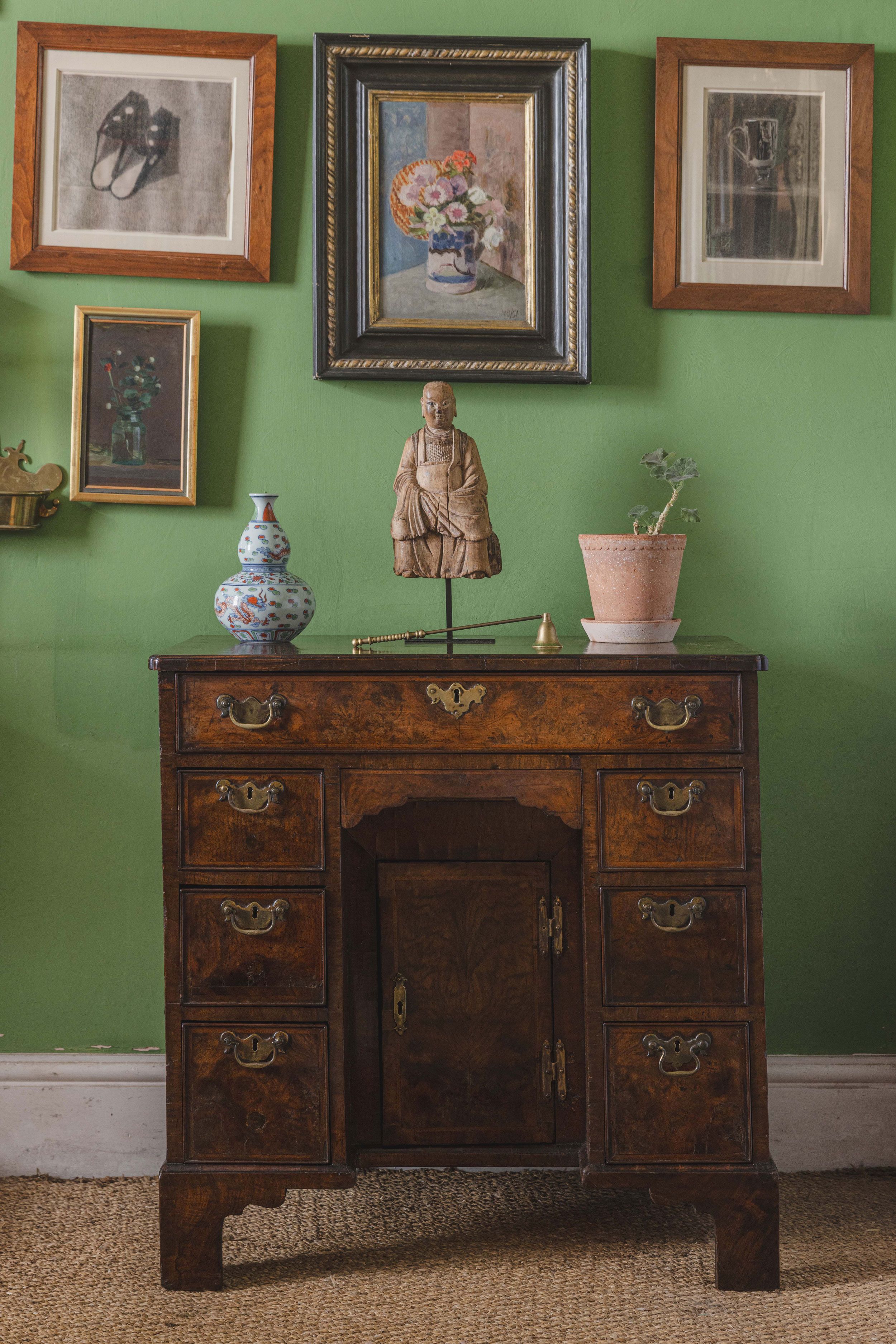 Image may contain: Furniture, Sideboard, Art, Painting, Plant, Person, and Cabinet