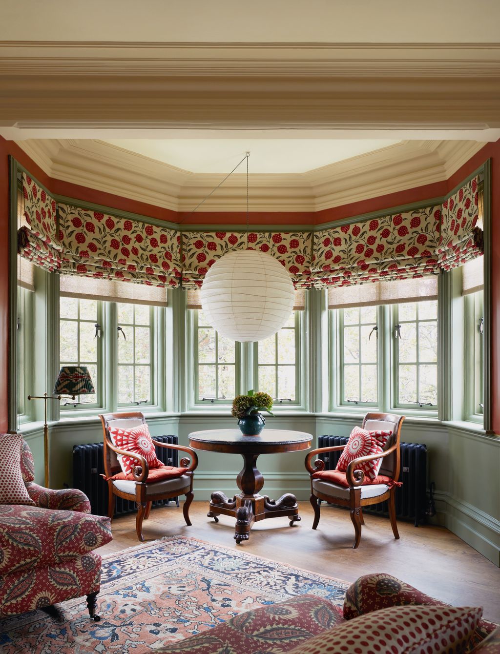 Image may contain Chair Furniture Plant Lamp Desk Table Window Home Decor Rug Bay Window and Couch