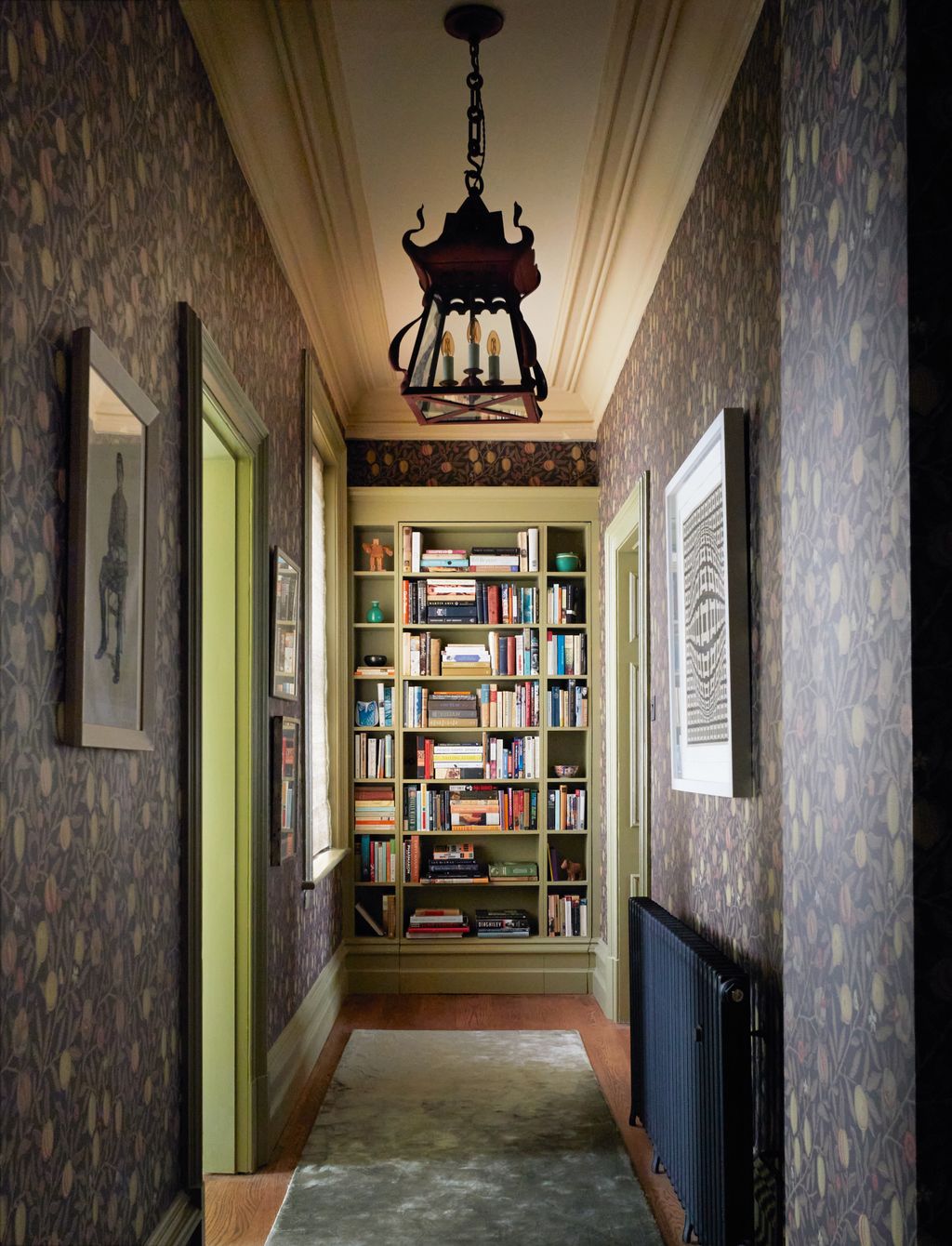 Image may contain Lamp Furniture Art Painting Home Decor Rug Bookcase Person Candle Chandelier and Indoors