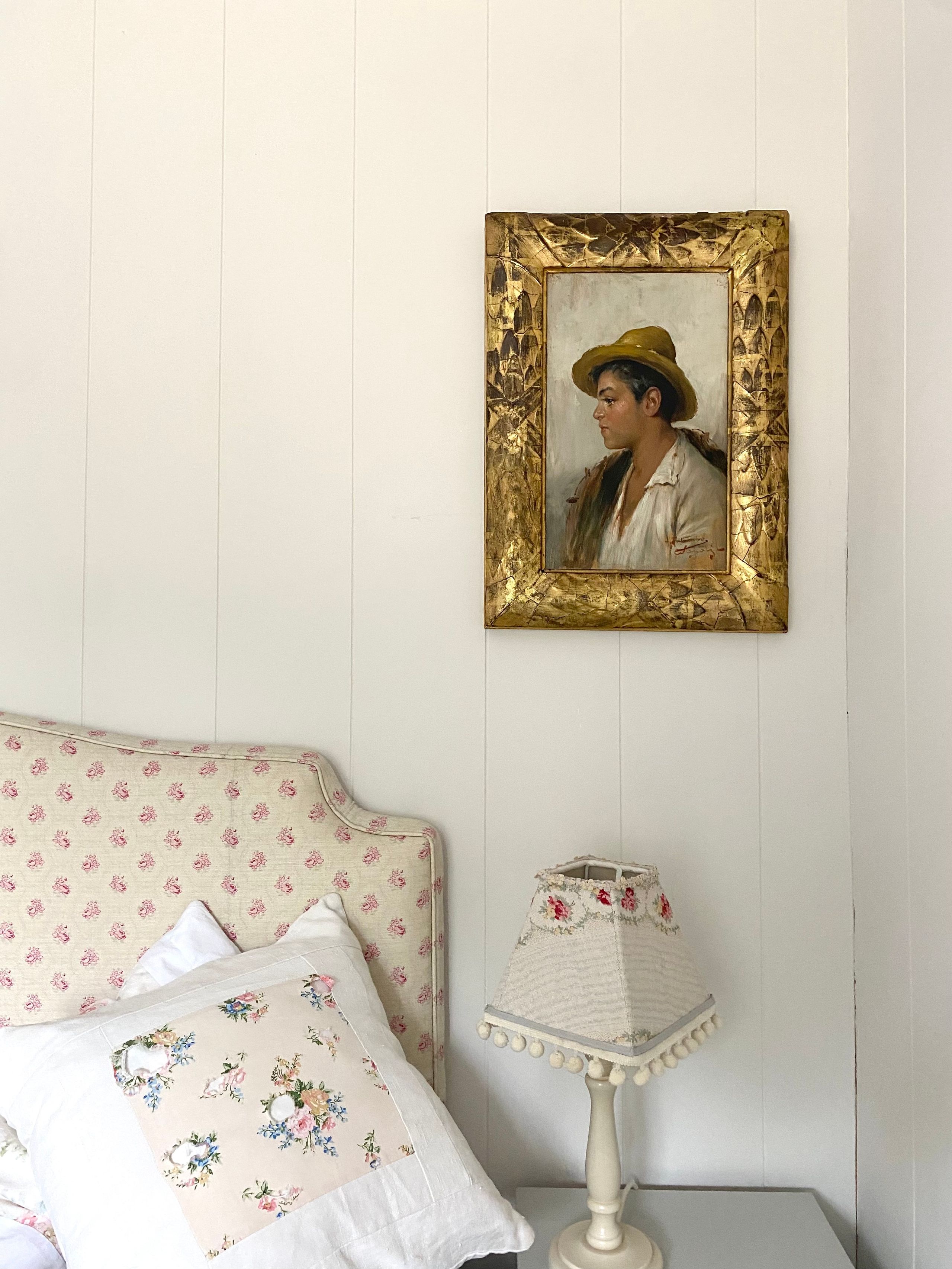 Image may contain: Lamp, Clothing, Hat, Art, Painting, Adult, Person, Bed, Furniture, and Photo Frame