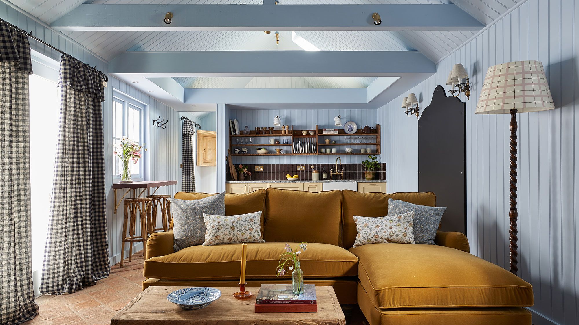 Image may contain: Home Decor, Architecture, Building, Furniture, Indoors, Living Room, Room, Lamp, Couch, Plant, and Book