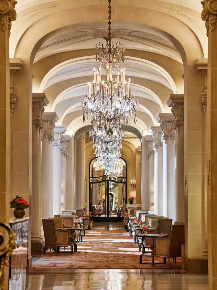 Image may contain Chandelier Lamp Indoors Chair Furniture Plant Floor Architecture Building and Foyer