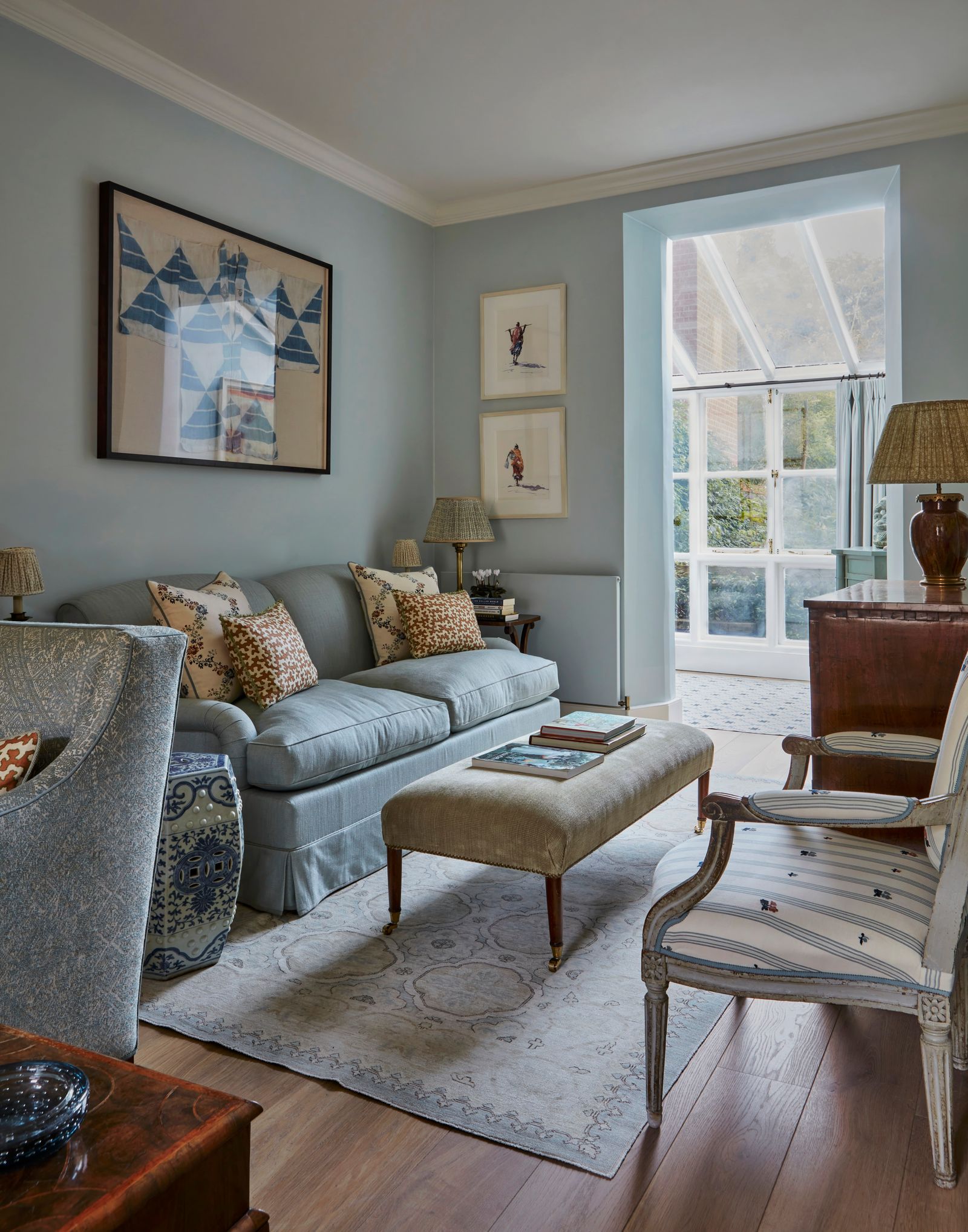 Image may contain Lamp Home Decor Chair Furniture Art Painting Book Publication Couch Rug Desk Table and Plant