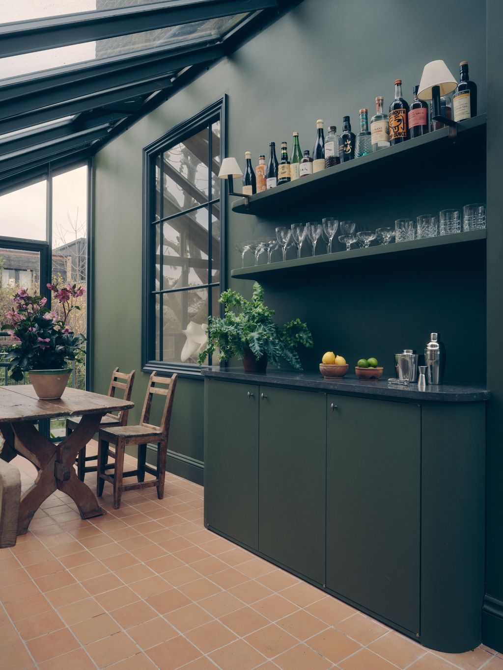 Image may contain Indoors Interior Design Plant Desk Furniture Table Floor Chair Dining Table Kitchen and Cup