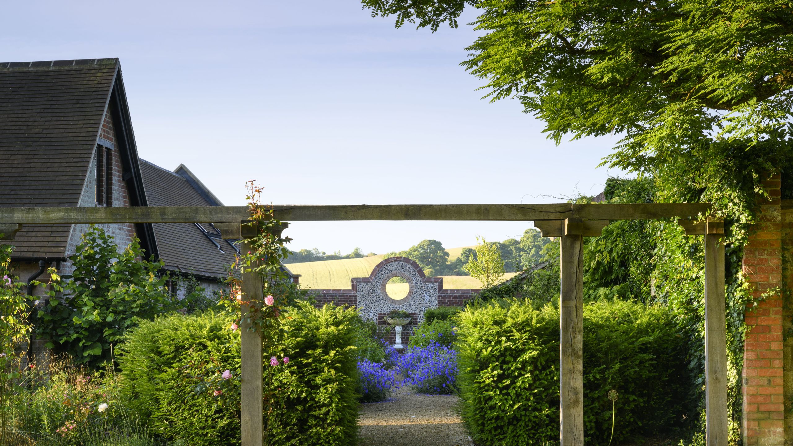 Image may contain: Garden, Nature, Outdoors, Architecture, Building, House, Housing, Porch, Arbour, Grass, Plant, and Fence