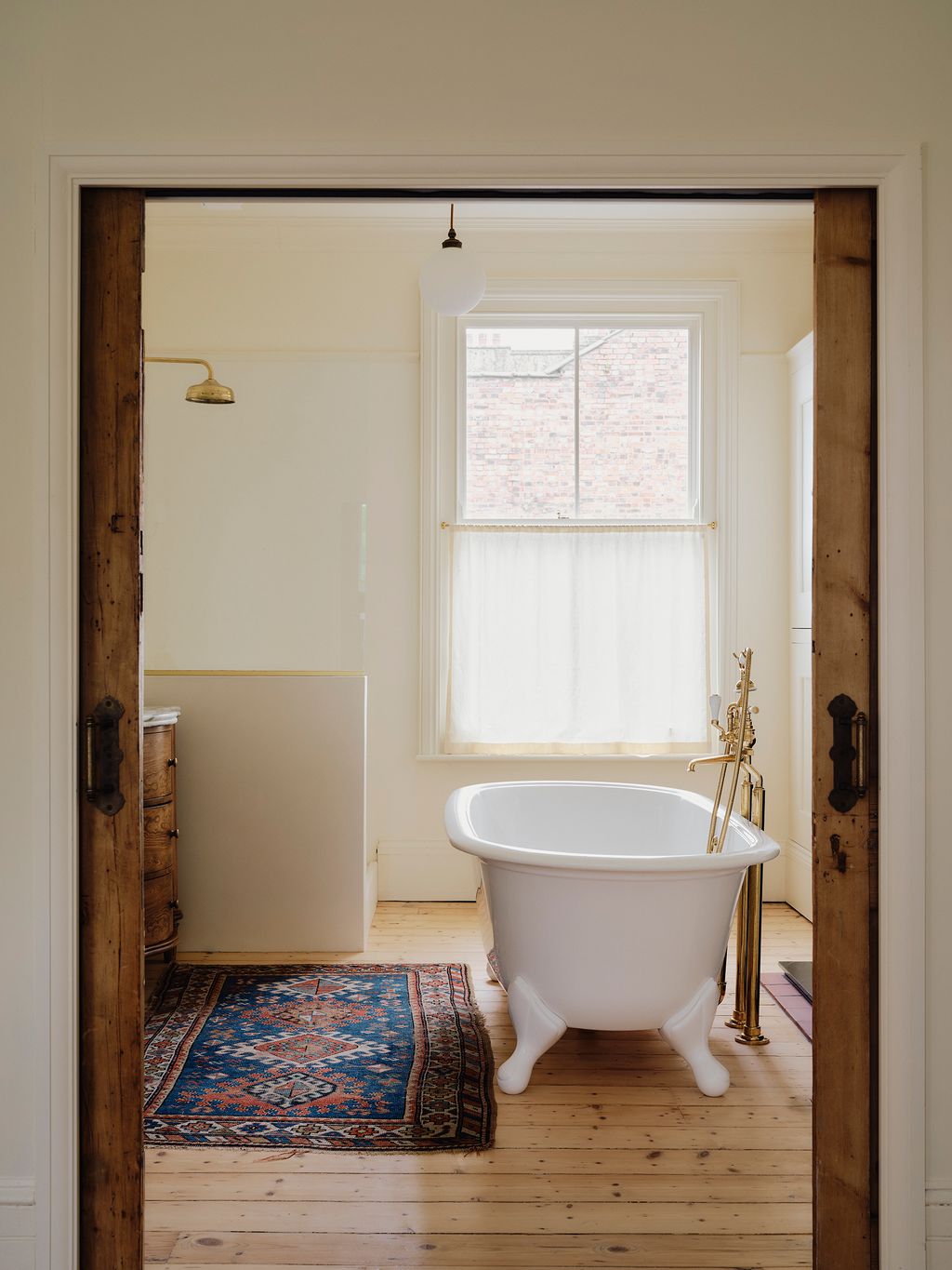 Image may contain Bathing Indoors Interior Design Lamp Bathtub Person Tub Home Decor Rug Sink and Sink Faucet