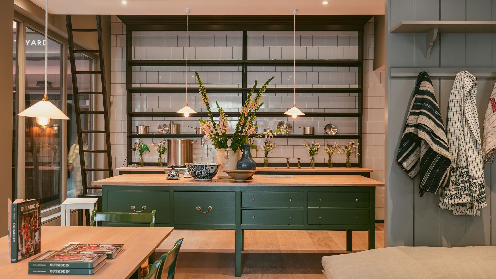 Image may contain: Indoors, Interior Design, Book, Publication, Lamp, Person, Furniture, Chair, and Flower