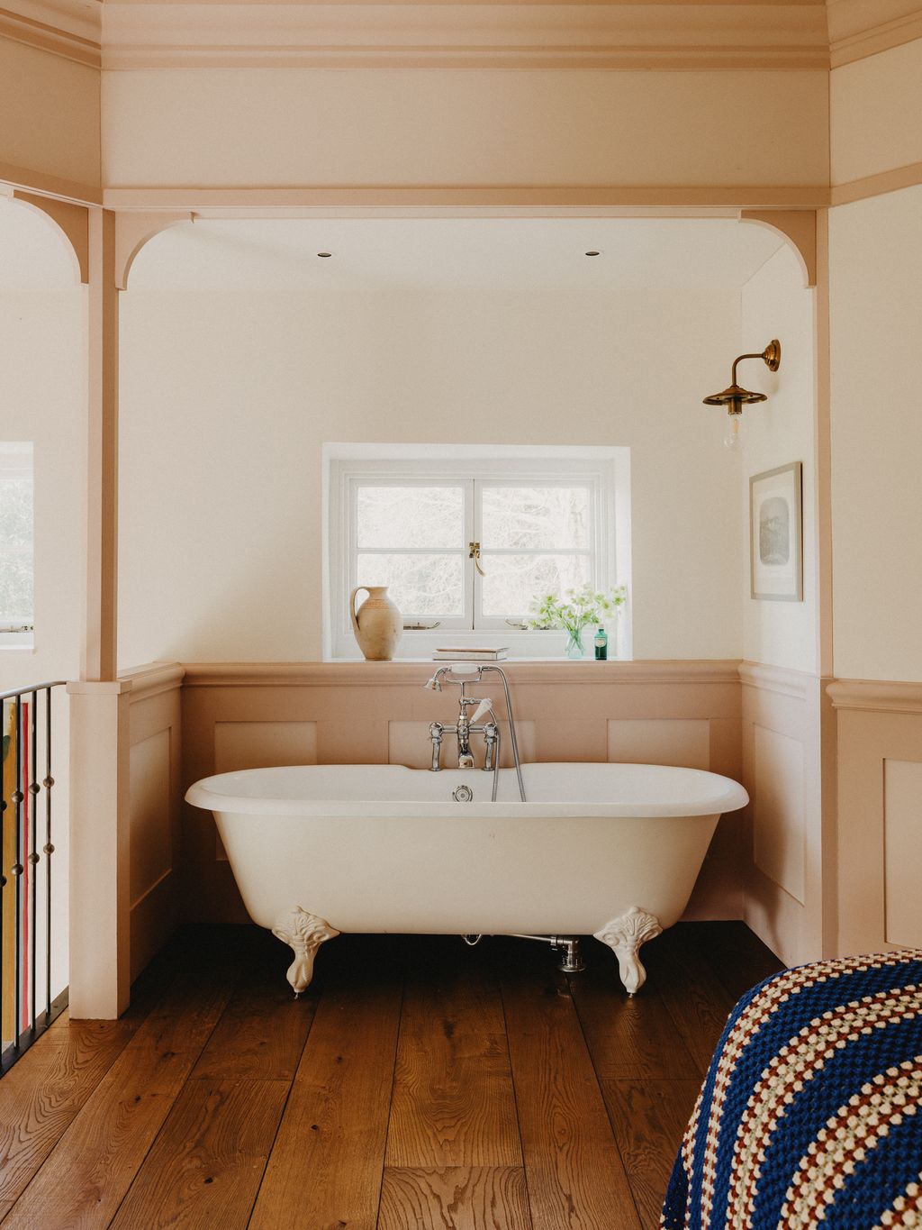 Image may contain Indoors Interior Design Bathing Bathtub Person Tub Art Painting Plant Lamp Sink and Sink Faucet