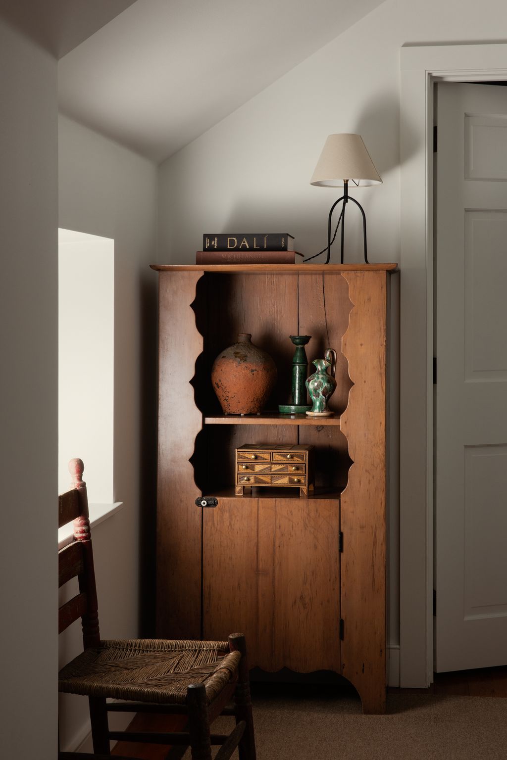 Image may contain Lamp Indoors Interior Design Chair Furniture Corner Wood Book Publication Closet and Cupboard