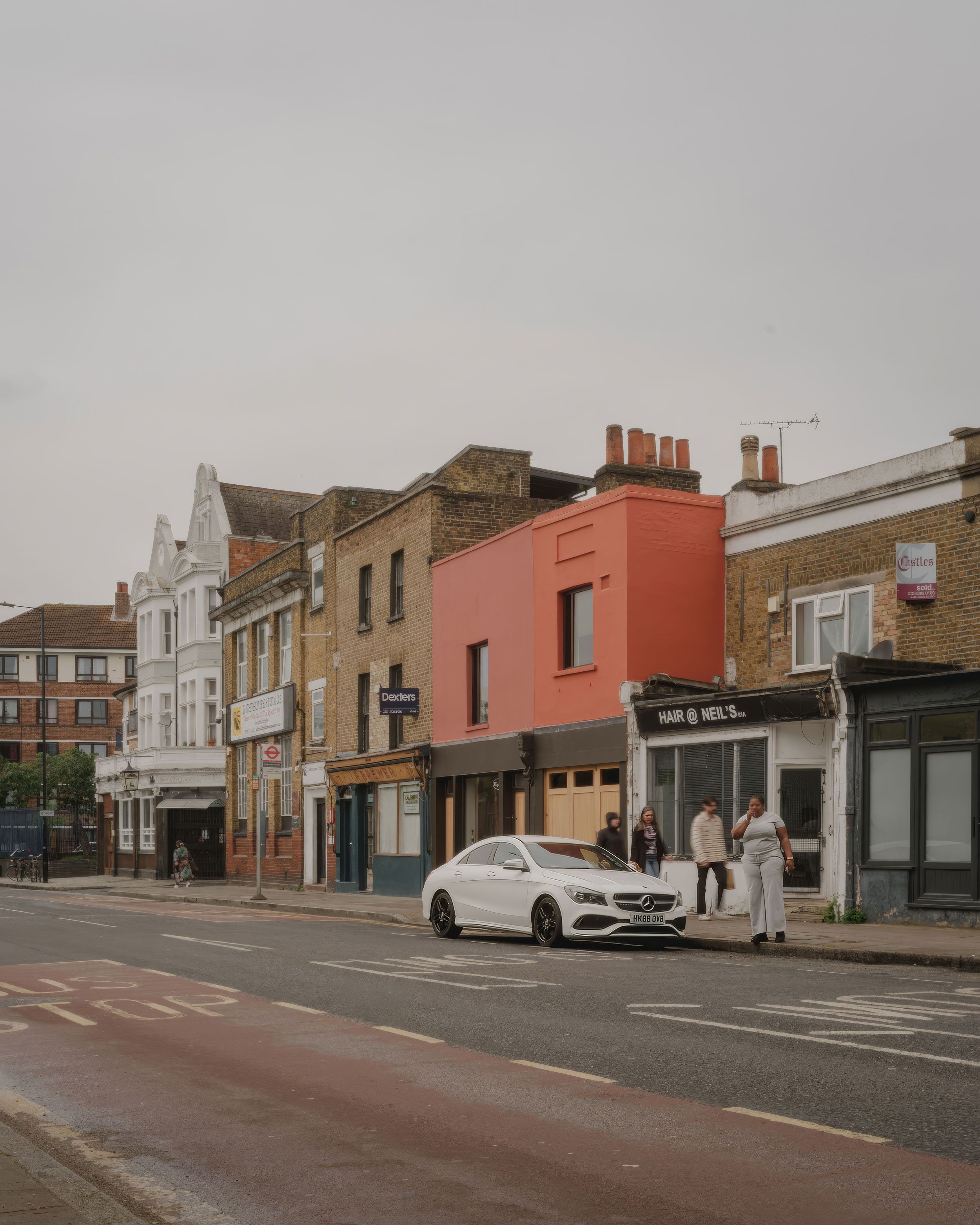 Image may contain: City, Road, Street, Urban, Neighborhood, Car, Transportation, Vehicle, Person, Architecture, and Building