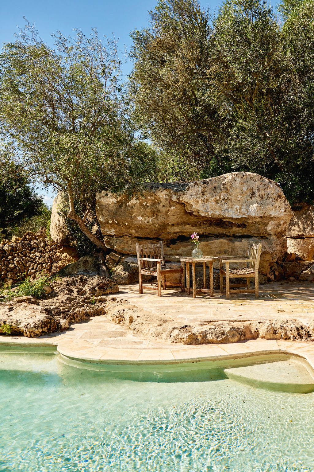 Image may contain Summer Rock Chair Furniture Pool Water Nature Outdoors Scenery Swimming Pool and Plant