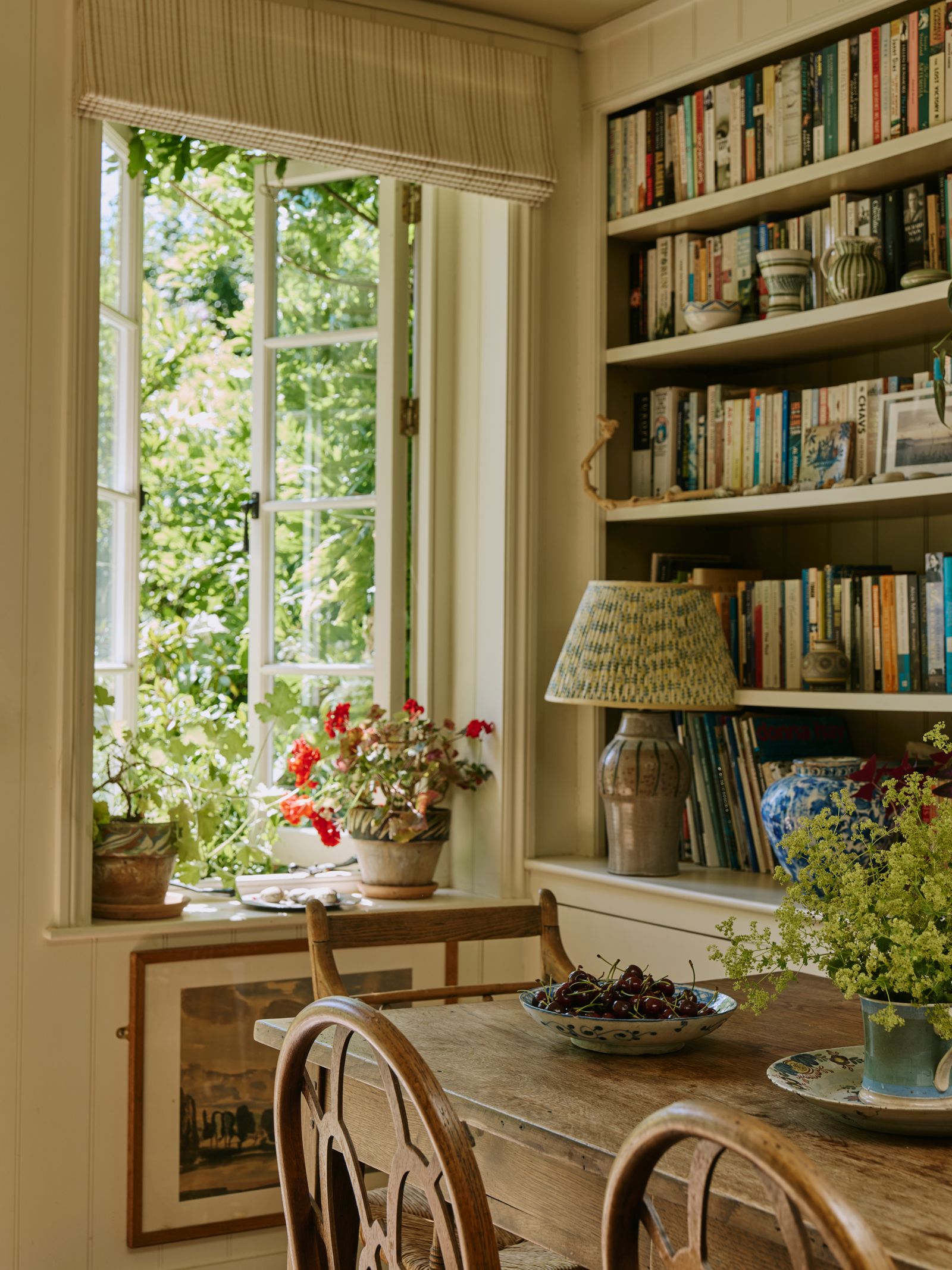 Image may contain Lamp Chair Furniture Window Plate Plant Bookcase Art Painting and Windowsill