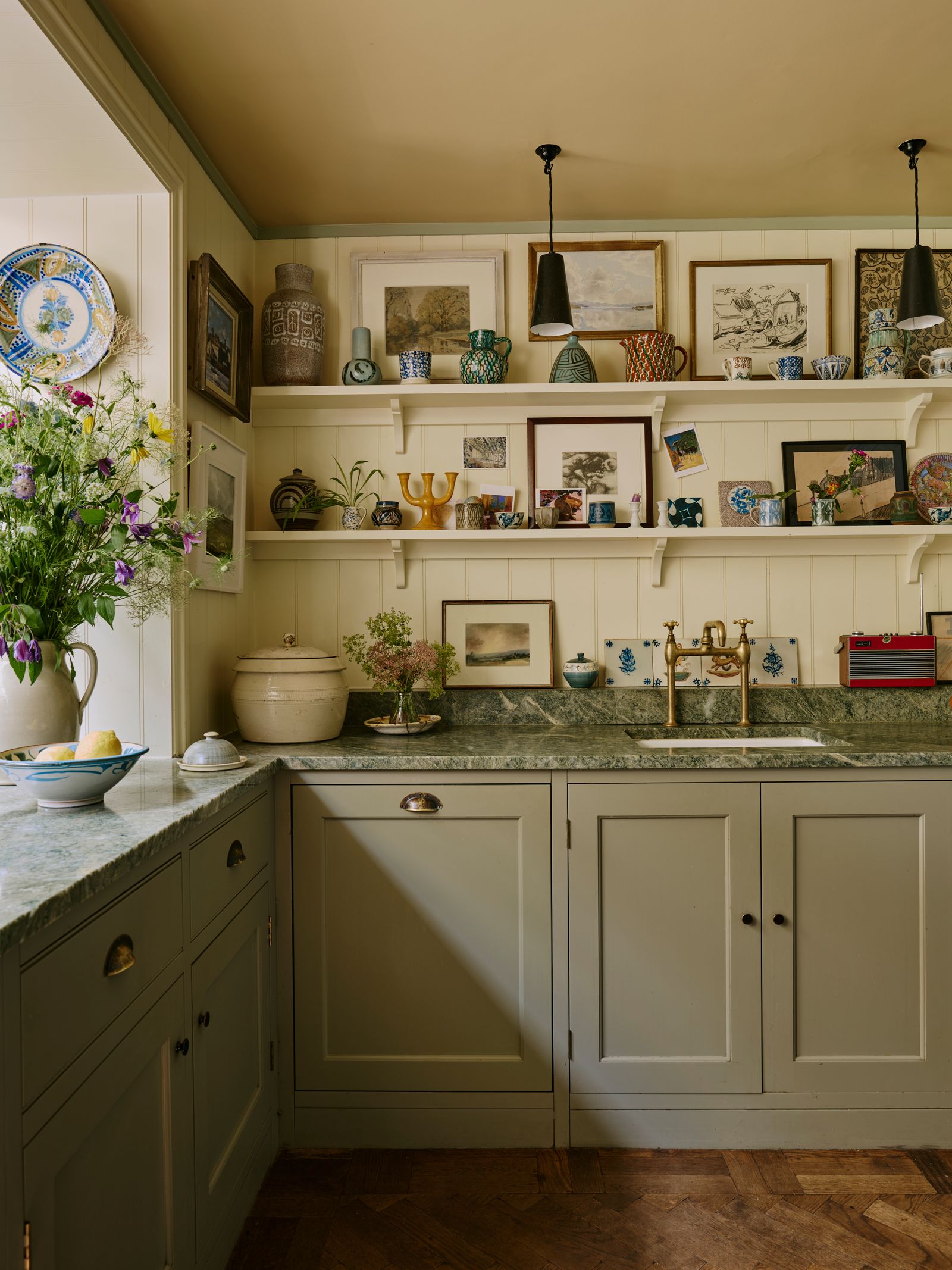 Image may contain Indoors Interior Design Sink Sink Faucet Lamp Art Painting Kitchen Plate Cup Plant and Box