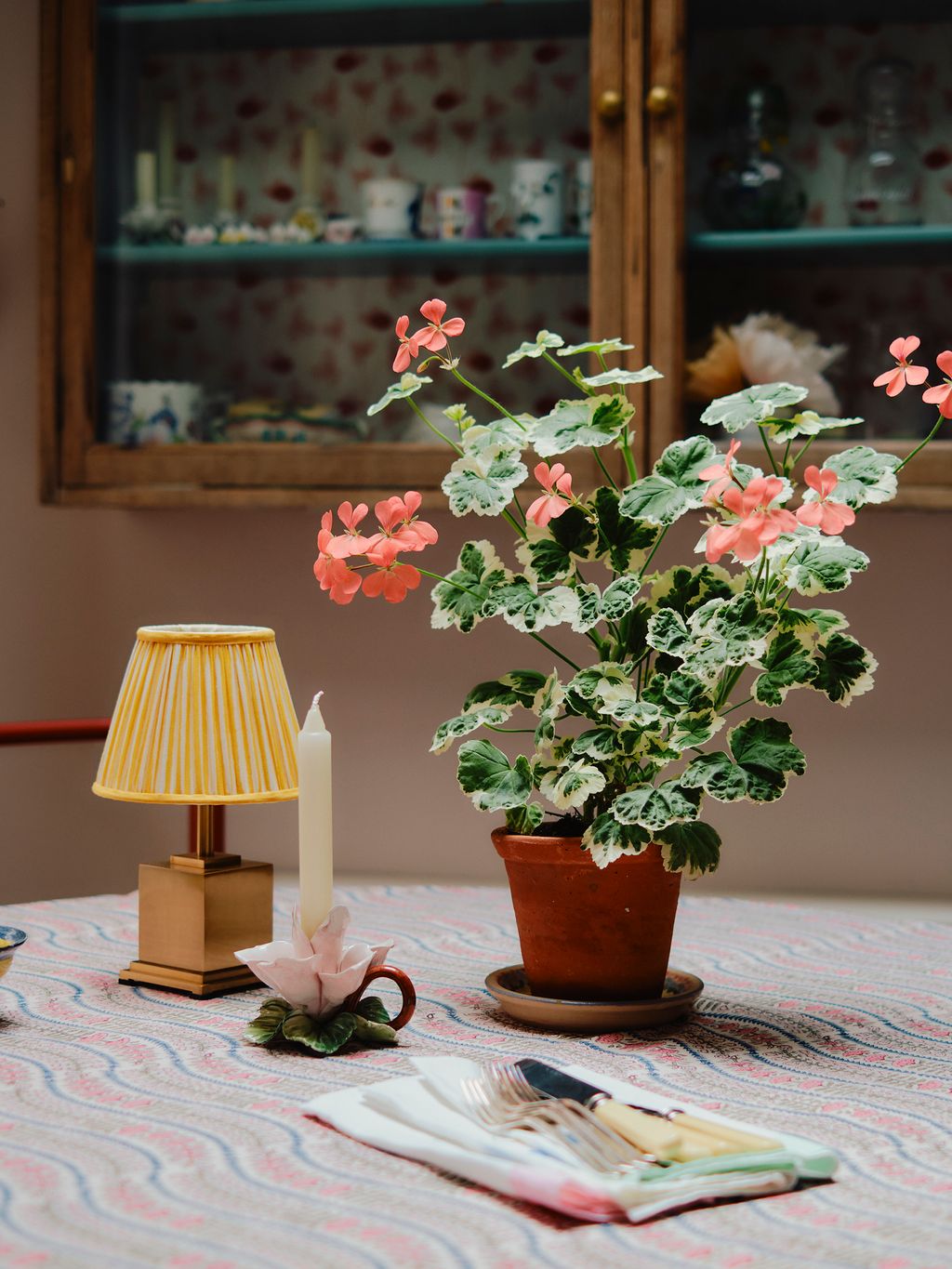 Image may contain Lamp Indoors Interior Design Plant Potted Plant Flower Flower Arrangement Candle and Geranium