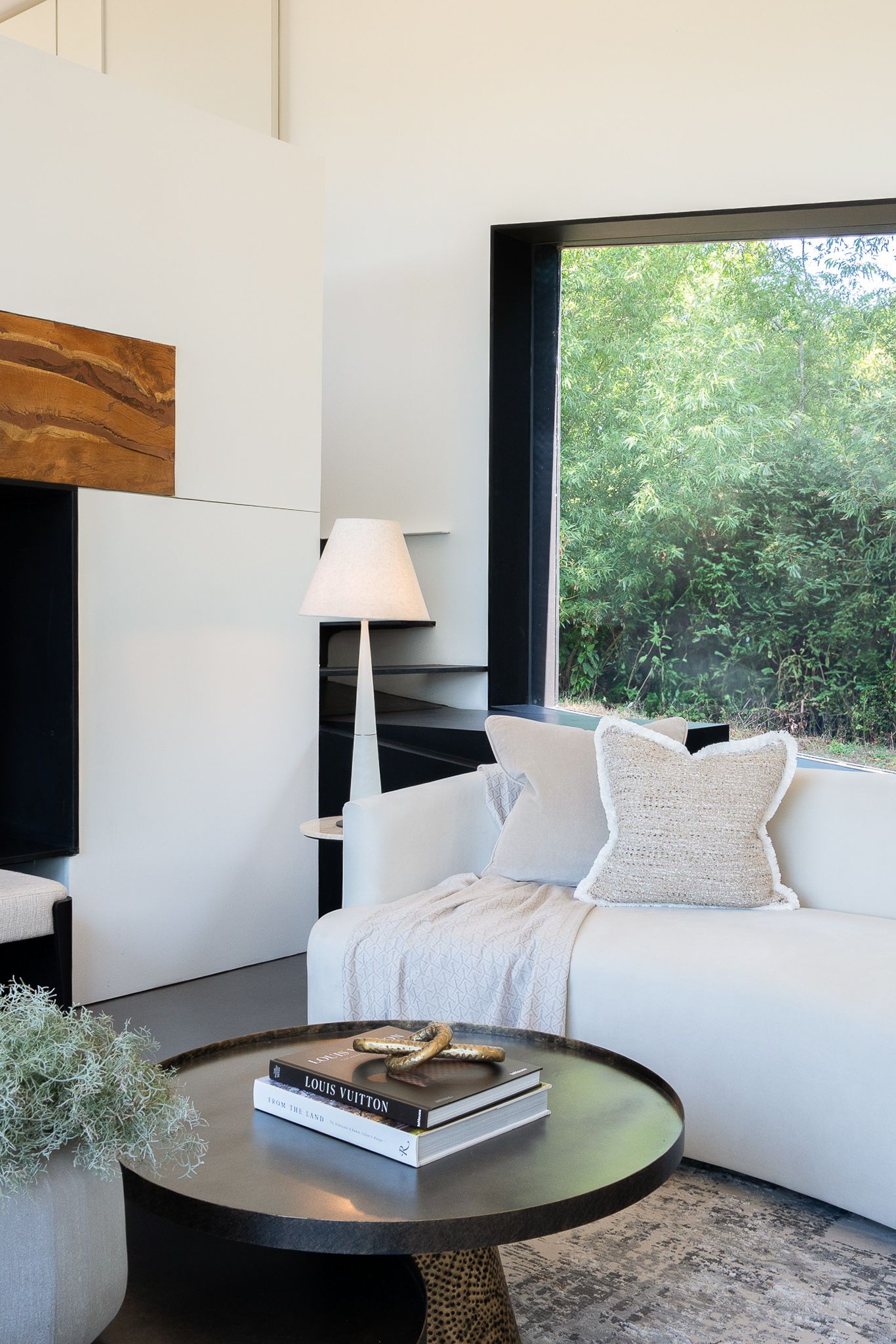 Image may contain: Coffee Table, Furniture, Table, Book, Publication, Lamp, Plant, Couch, Home Decor, and Indoors