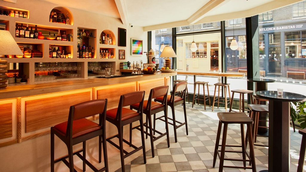 Image may contain Chair Furniture Lamp Cup Bar Art Painting Desk Table Person Pub and Dining Table