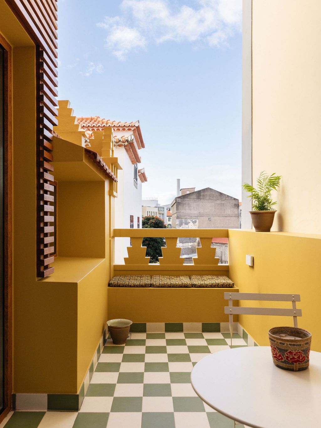 Image may contain Architecture Balcony Building Plant Desk Furniture Table and Chair