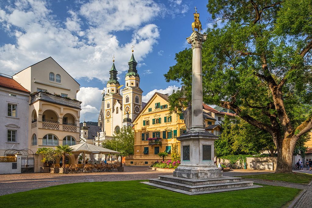 Image may contain City Urban Architecture Building Clock Tower Tower Downtown Grass Plant Arch and Gothic Arch